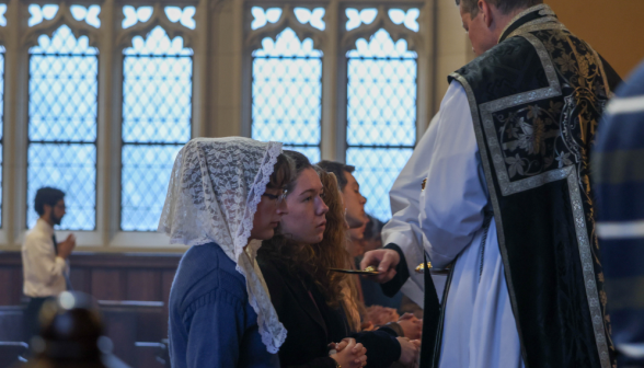 Fr. distributes communion to the laypeople