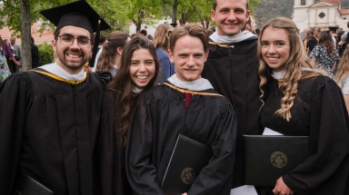Five graduates, smiling