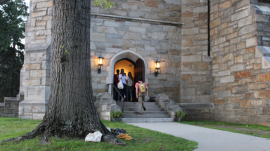 Students enter the Chapel as the sun goes down and the lamp come on