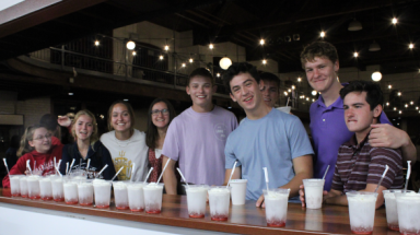 A row of students at the coffee shop counter, afront a row of Italian sodas
