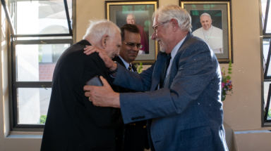 President Michael F. McLean welcomes retired TAC chaplain Rev. Cornelius M. Buckley, S.J., who made a surprise at the President’s Dinner to celebrate the Class of 2022