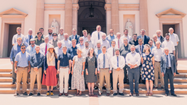 Faculty from both campuses pose together for a photo on the steps of the California chapel