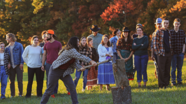 A student tries her hand at the log-chopping contest