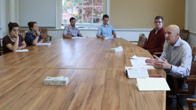 Rick Brajer addresses the students at a classroom table