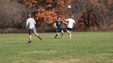 The ball comes down as players rush toward it