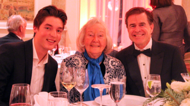 Three pose for a photo at one of the tables