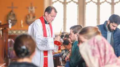 Fr. Markey blesses students with the relic before finals