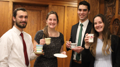 Four pose for the camera, teacups in hand