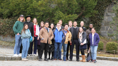The trip-takers pose for a photo afront a stone wall
