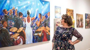 Kathryn Claahsen looks at one of her artworks on a wall