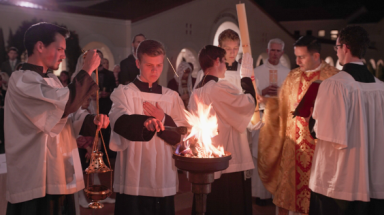 Altar servers light the thurible from the sacred fire