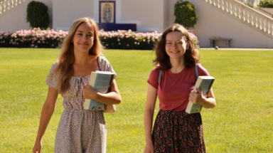 Two students walk across campus