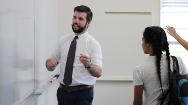 Tutor demonstrates for students on a white board