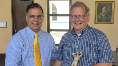 Dr. John J. Goyette, outgoing dean of the California campus, presents Dr. Sean Collins with a statue of “Lady Philosophy,” in honor of his teaching all 23 courses in the TAC curriculum.