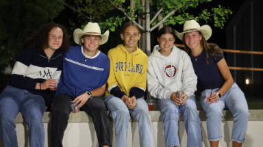 Five pose together on a ledge