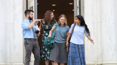 A tutor discusses Euclid with three students at the door of Palmer