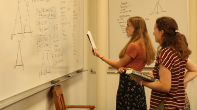 Students demonstrate a prop at the board