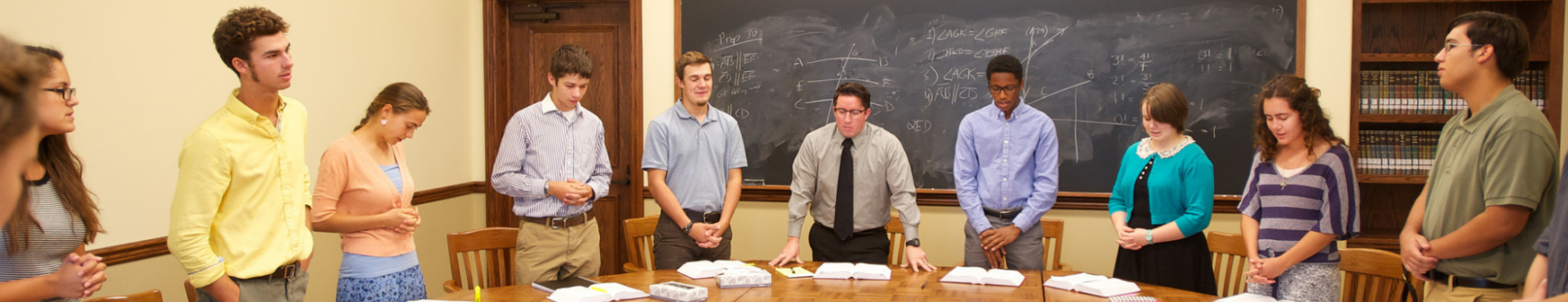 Students stand in prayer at the start of class