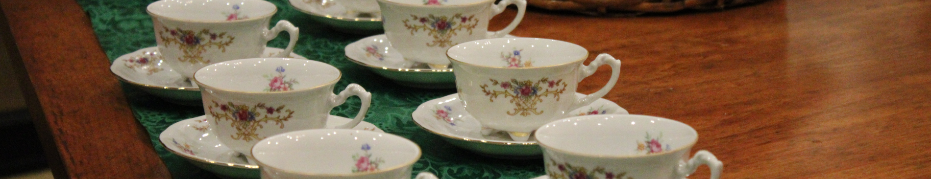 Ornate china teacups laid out in double rows