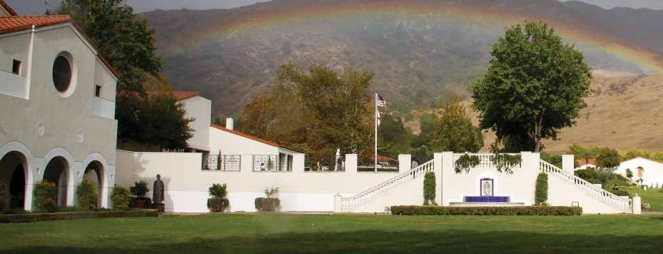 Rainbow across a mountain above white buildings