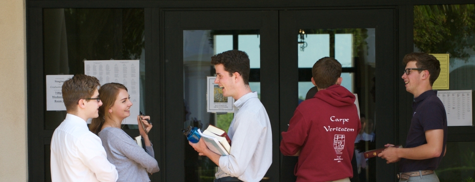 Five people standing outside glass doors talking