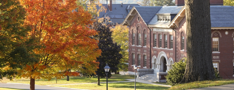 Red brick building with lots of different colored trees around it