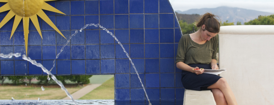 Student reads at a fountain