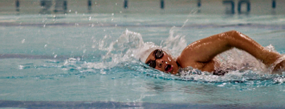 Student swimming in the New England pool