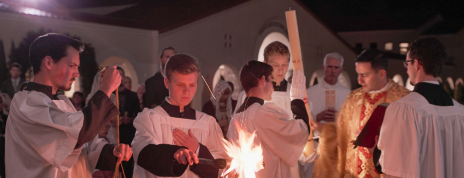 Altar servers light the thurible from the sacred fire