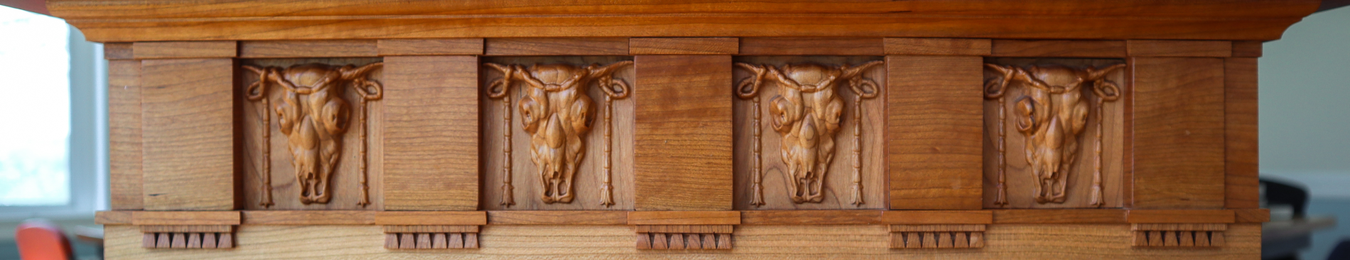 Closeup of a row of carven ox skulls on the lectern
