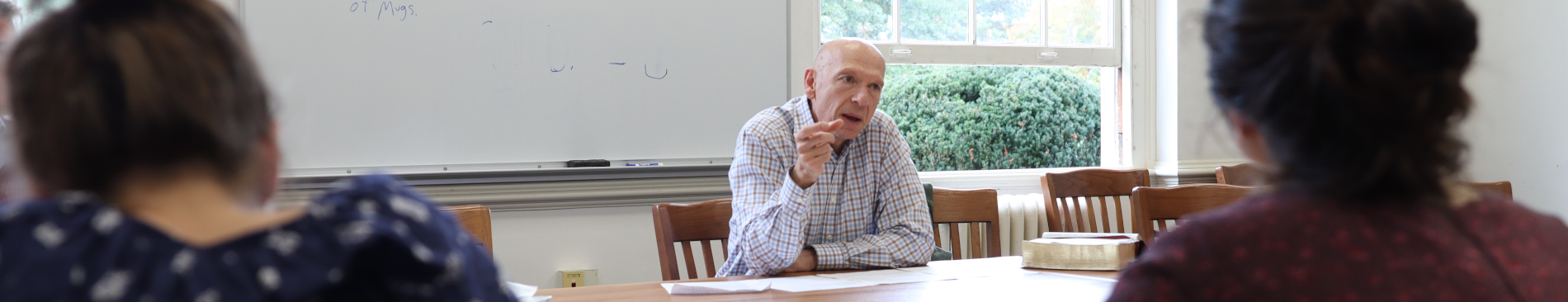 Rick Brajer addresses the students at a classroom table