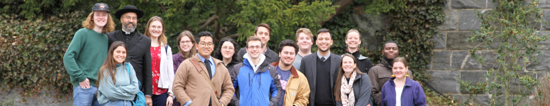 The trip-takers pose for a photo afront a stone wall