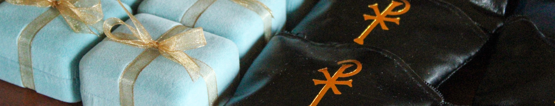 Small baby-blue boxes and rosary pouches await blessing