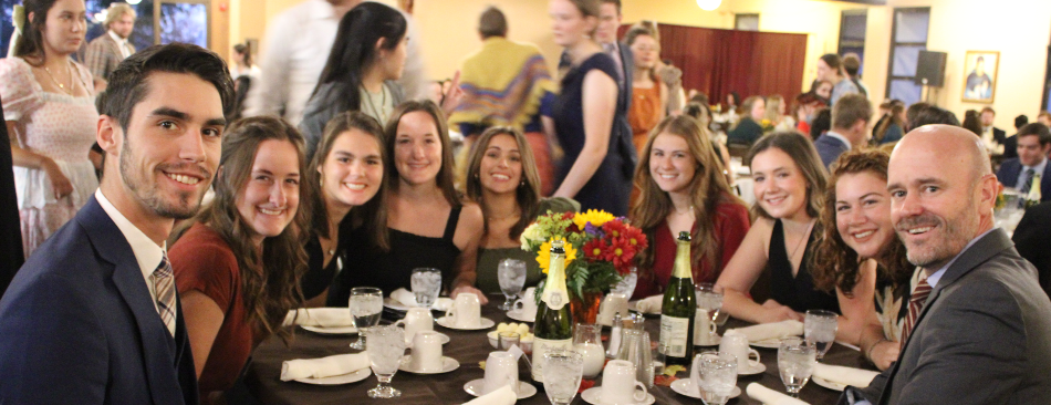 Nine at a table pose for a photo