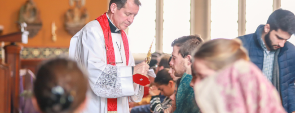 Fr. Markey blesses students with the relic before finals